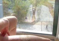 Mature masturbates by the window