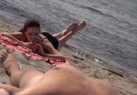 Girl on the beach looks at dick