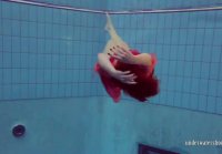 Red Haired woman swims underwater in red silk boards