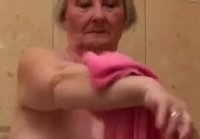 Grandma with big boobs washes her flabby body in the bathroom