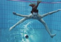 Slim girl swims and exposes herself underwater in the pool