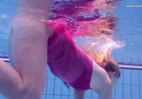 Playful blonde swims naked in the olympic pool